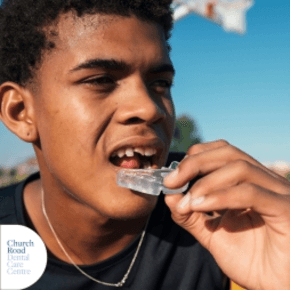 A close up of a young man putting a mouth guard in outdoors